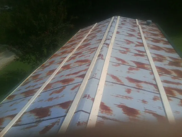 Rusted metal roof panels with new wood purlins before replacement — Storm Damage Roof Repair in Mantoloking by Roofing Brothers