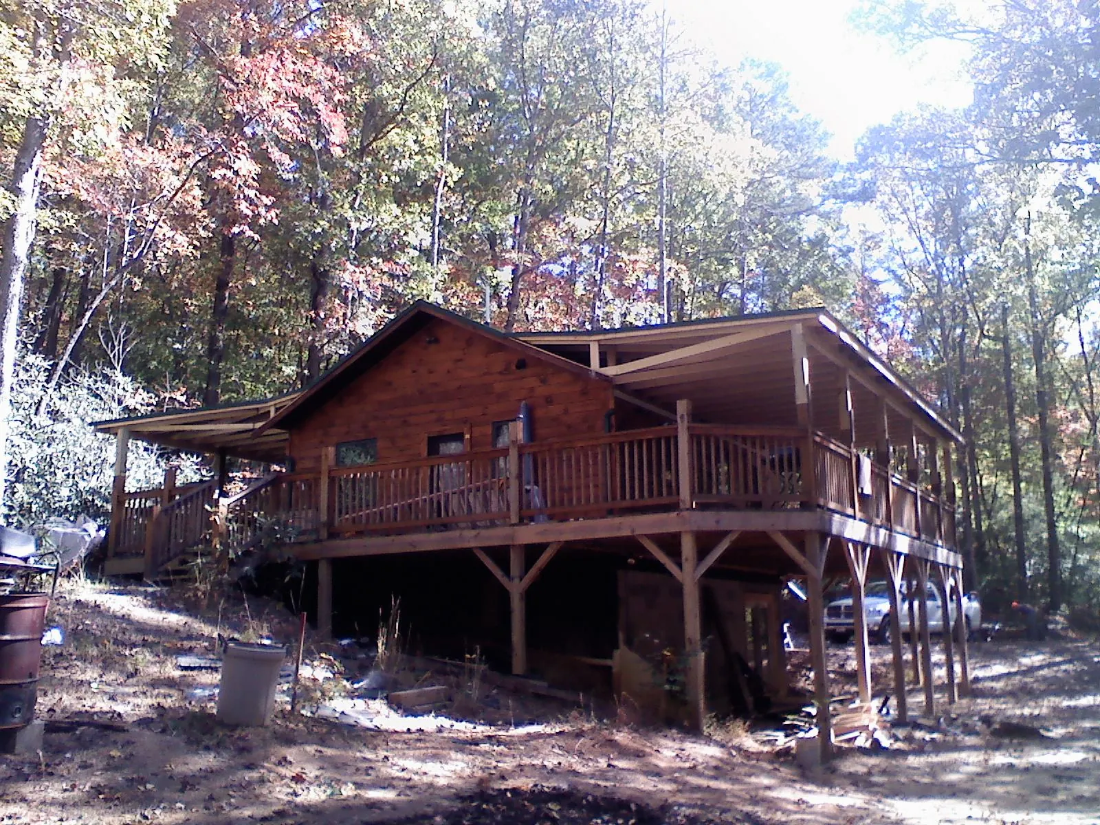 Log cabin with a wraparound porch and metal roof in the fall in Mantoloking
