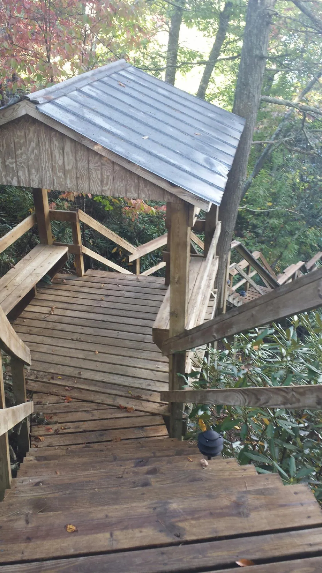 Metal roofed shelter over wooden steps on a wooded walkway — Skylight Repair & Installation work by our crew in Mantoloking